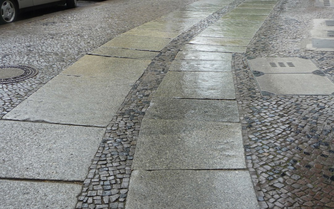 Two paths marked with paving stones along a sidewalk.